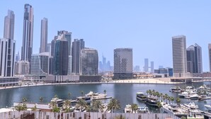 A marina with boats, a clear sky, and modern high-rise buildings in the background. - 15 Northside - 210A · Contemporary Ranch Living with Burj Khalifa View (Dubai)