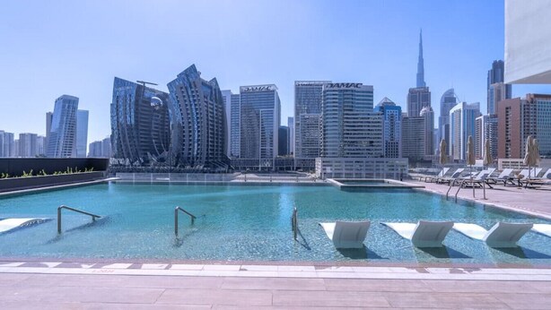 A rooftop pool with a city skyline in the background. - 15 Northside - 210A · Contemporary Ranch Living with Burj Khalifa View (Dubai)