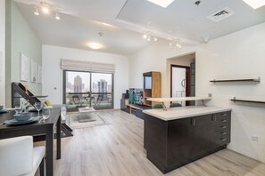 A modern kitchen with a central island, dining area with a view, and a large window.