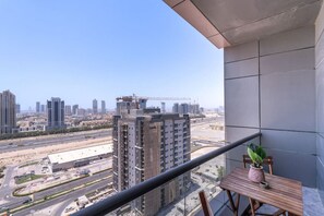 A balcony with a view of a cityscape, including high-rise buildings and a construction site.