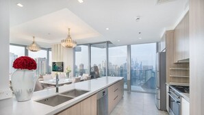 Eine moderne Küche mit einer großen Kochinsel, einem Essbereich und Blick auf die Stadt.
