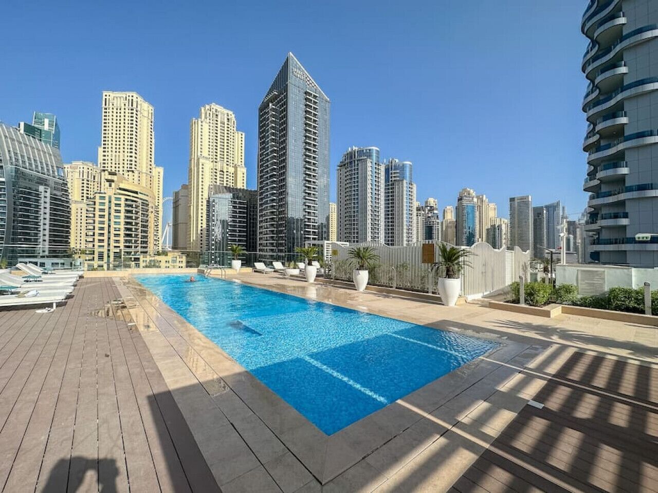 Une piscine sur le toit avec la vue sur les grat-ciel de la ville en arrière-plan.