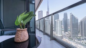 Un interior moderno con una planta en maceta sobre una mesa de vidrio, un balcón con vistas a la ciudad.