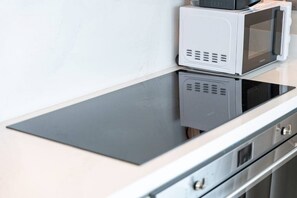 Eine Küche mit integriertem Mikrowellenherd und einem Edelstahlbackofen.