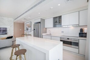 Una cocina moderna con una isla central, electrodomésticos de acero inoxidable y un diseño minimalista.