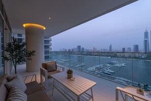 A modern balcony with a view of a marina and city skyline.