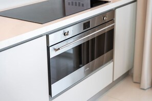 Uma cozinha moderna com eletrodomésticos de aço inoxidável, incluindo forno e micro-ondas.