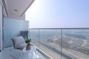 A modern balcony with a clear view of a cityscape. - Floral Charm studio in Damac Hills by Suiteable (Dubai)