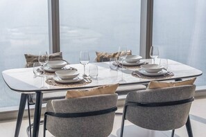 A dining table set for four with a view of the city through large windows.