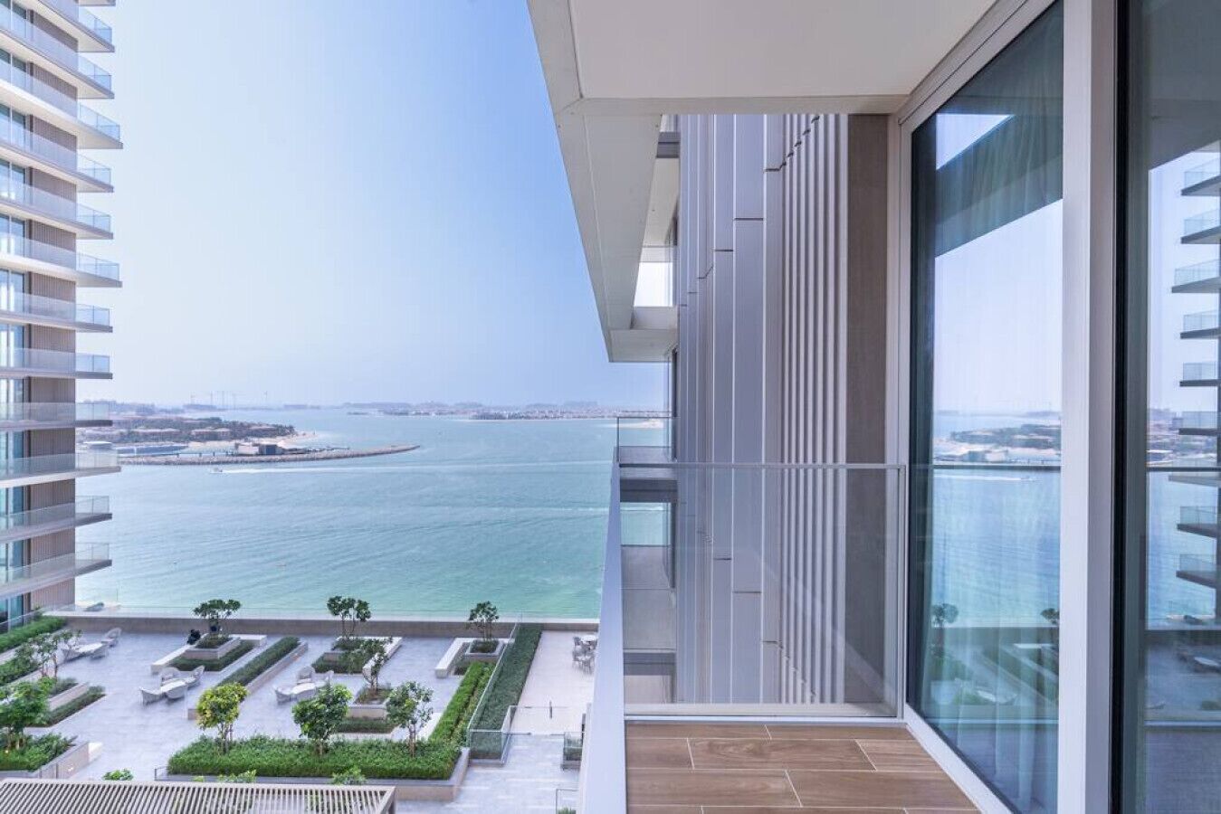 A modern apartment with a balcony overlooking a marina and the sea.