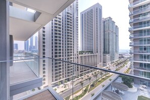 Um edifício residencial alto com várias varandas, janelas amplas e vista para o horizonte urbano.