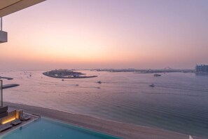Vista da área costeira com piscina, marina e edifícios ao longe.