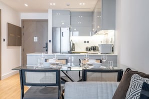 Une cuisine moderne avec un coin repas, comprenant une table dressée pour quatre personnes, ainsi que des chaises.