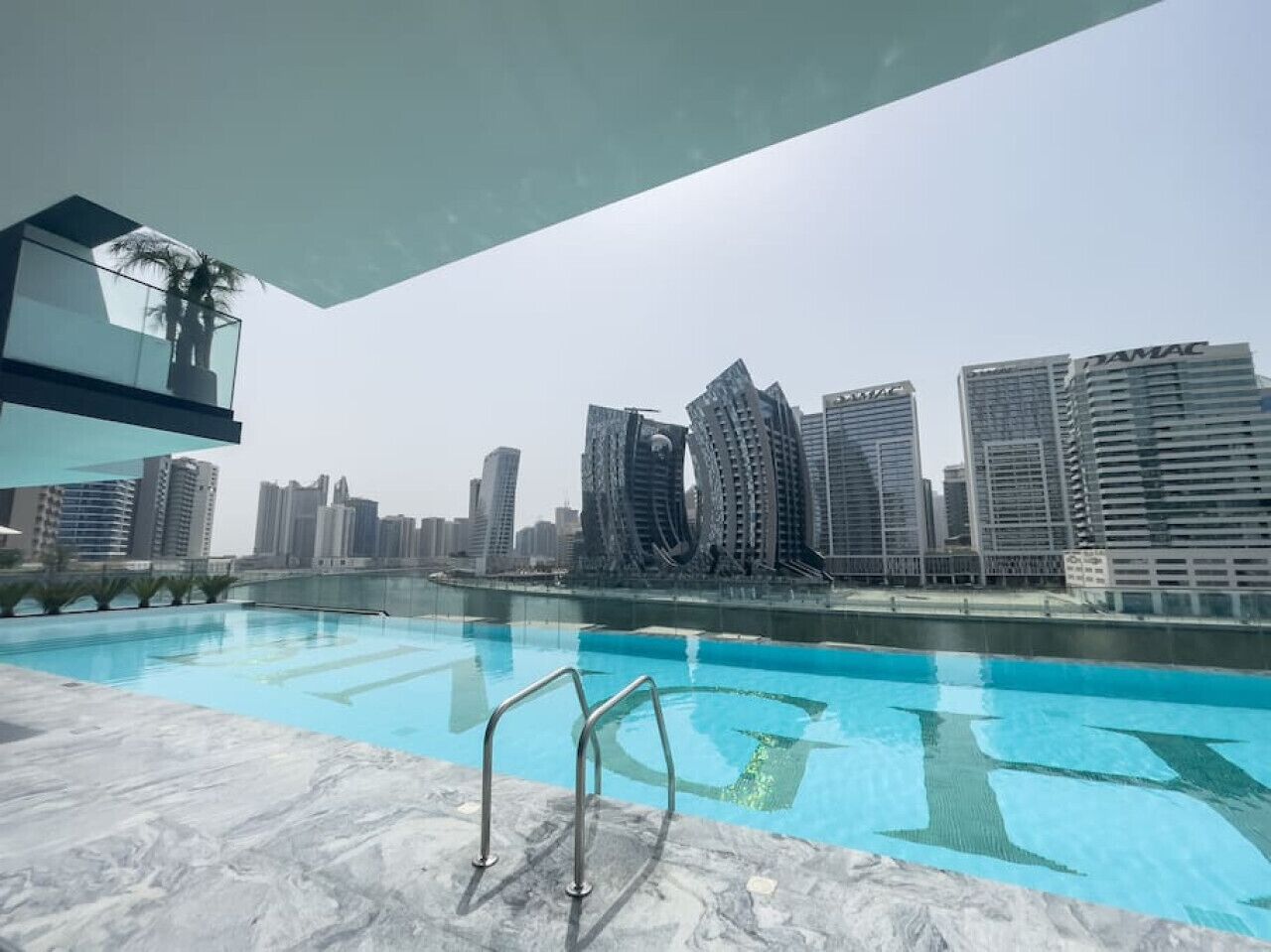 A swimming pool with a city skyline in the background.