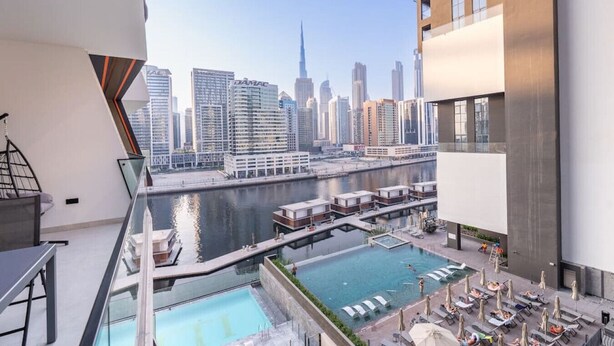 Un immeuble de grande hauteur doté d’une piscine, offrant une vue sur le panorama urbain et présentant un design architectural moderne.