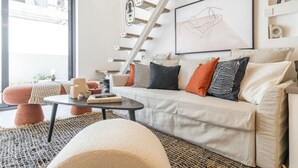 Una sala de estar moderna con un sofá, una mesa de centro y una escalera.
