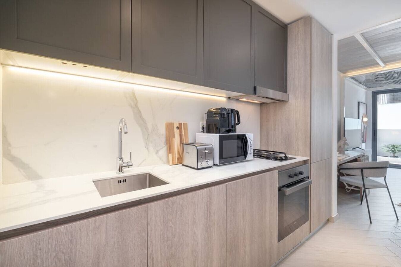 Eine moderne Küche mit integriertem Mikrowellenherd, Toaster und Kaffeemaschine auf der Arbeitsfläche.