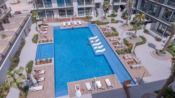 Una piscina en la azotea con tumbonas y terraza de madera.