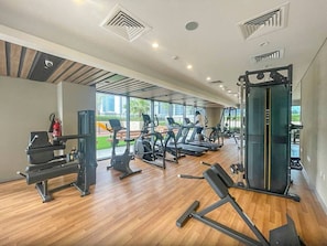 A gym with treadmills, weight machines, and a squat rack.