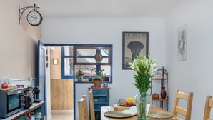 Un comedor con una mesa de madera, sillas, un reloj y una ventana con vistas.