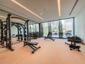 Ein Fitnessraum mit Krafttrainingsgeräten, Bänken und Kurzhanteln.