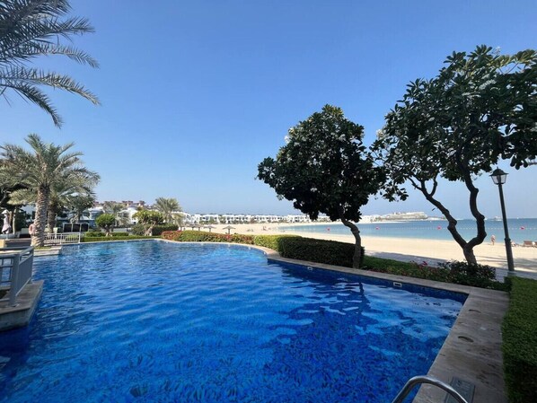 A swimming pool with a view of the beach and ocean.