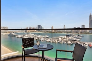 A balcony with a view of a marina and city skyline.