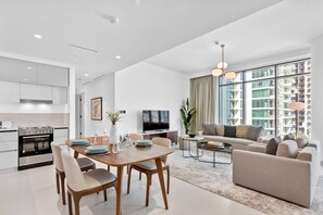 A modern apartment with a kitchen, dining area, and living room. - Luxurious Living in the heart of Emaar Beachfront (Dubai)