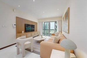 Uma sala de estar moderna com um sofá, uma mesa de centro, uma televisão e um abajur de pedra.