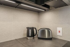 Une cuisine moderne avec une bouilloire et un grille-pain posés sur le plan de travail.