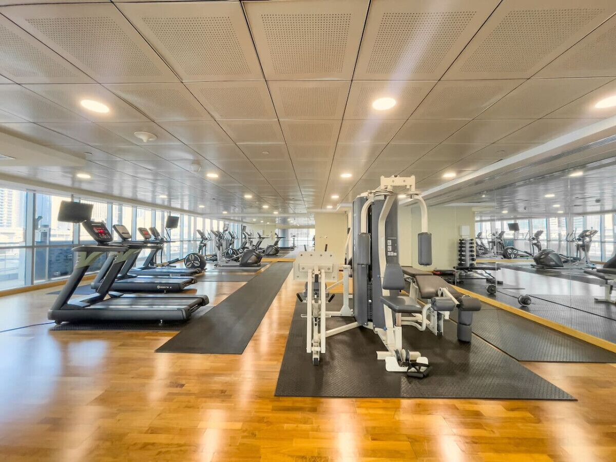 A spacious gym with treadmills, elliptical machines, and weight equipment.