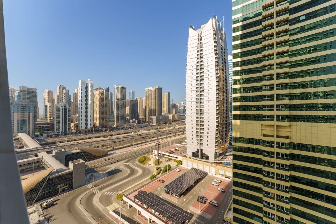 A high-rise building with a modern design, surrounded by other tall buildings in a cityscape.