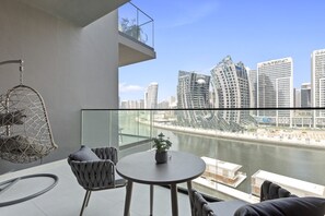 A balcony with a view of a river and modern buildings.