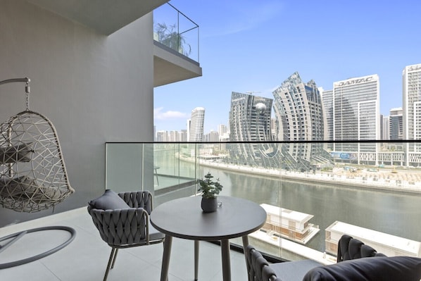 A balcony with a view of a river and modern buildings.