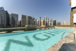 A swimming pool with a city skyline in the background.