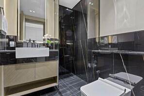 A modern bathroom with a black and white marble design, a large mirror, and a shower area.