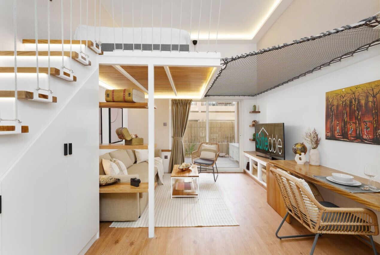 Ein modernes Interieur mit Schlafzimmer im oberen Bereich, einer Essecke und einem Wohnbereich.