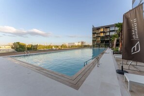 A modern swimming pool with a clear view of the city skyline in the background.