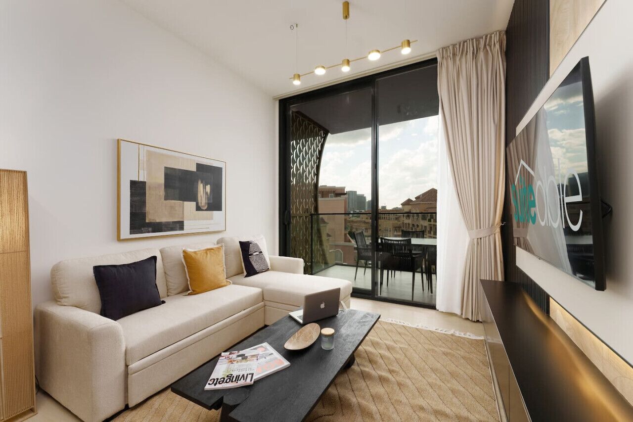 A modern living room with a sofa, a coffee table, and a TV.