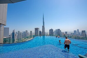 A rooftop infinity pool with a city skyline view, including a prominent skyscraper. - Experience Opulent Living at Paramount Midtown (Dubai)