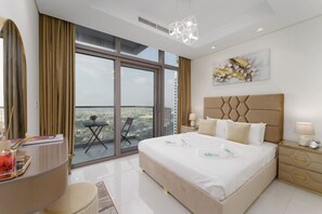 Een moderne hotelkamer met een groot bed, uitzicht op de stad en een balkon met een tafel en stoel.
