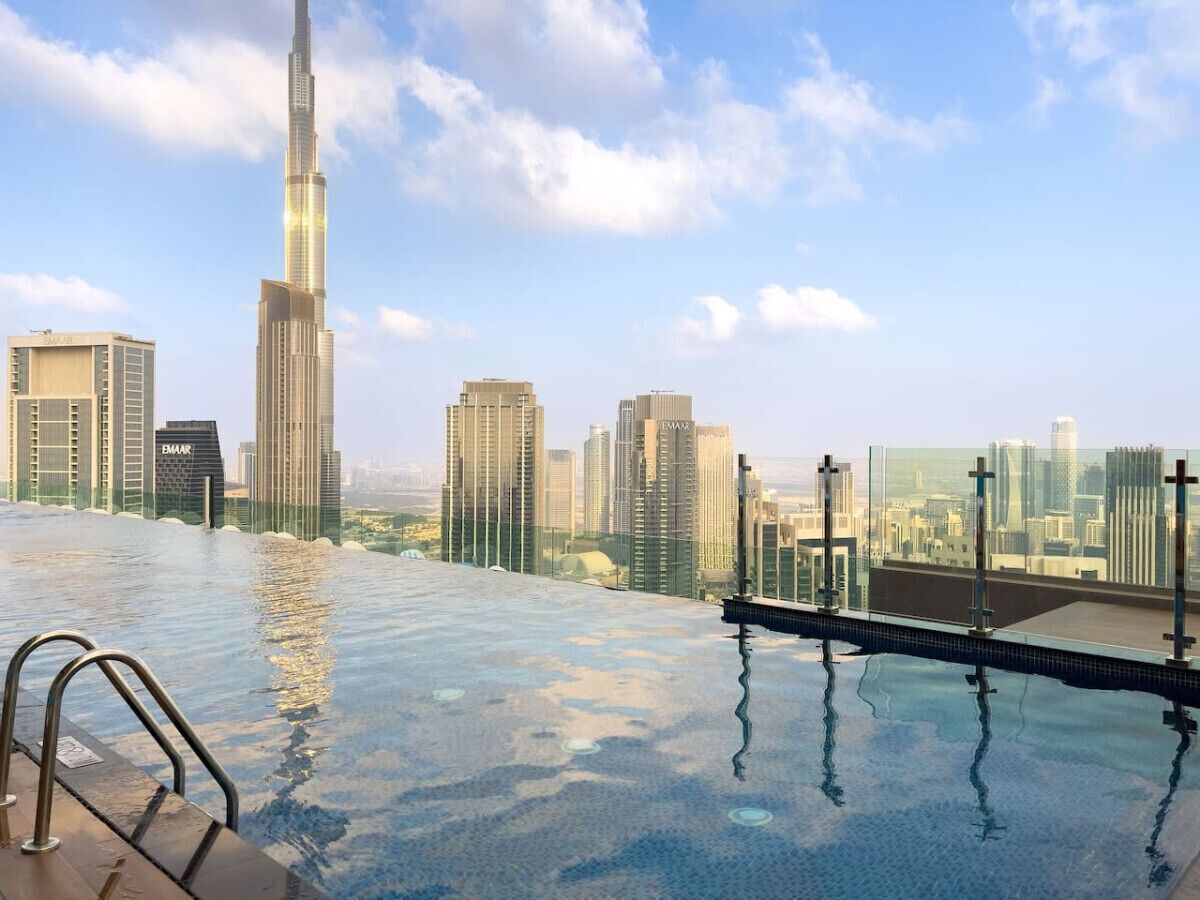 A rooftop infinity pool with a city skyline view, including the Burj Khalifa.
