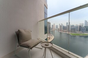 Un balcón con vistas a un horizonte urbano y una masa de agua.