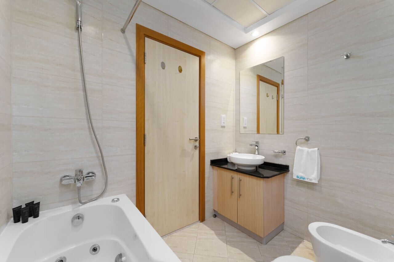 A modern bathroom with a bathtub, a sink, and a shower.