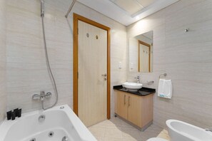 A modern bathroom with a bathtub, a sink, and a shower.