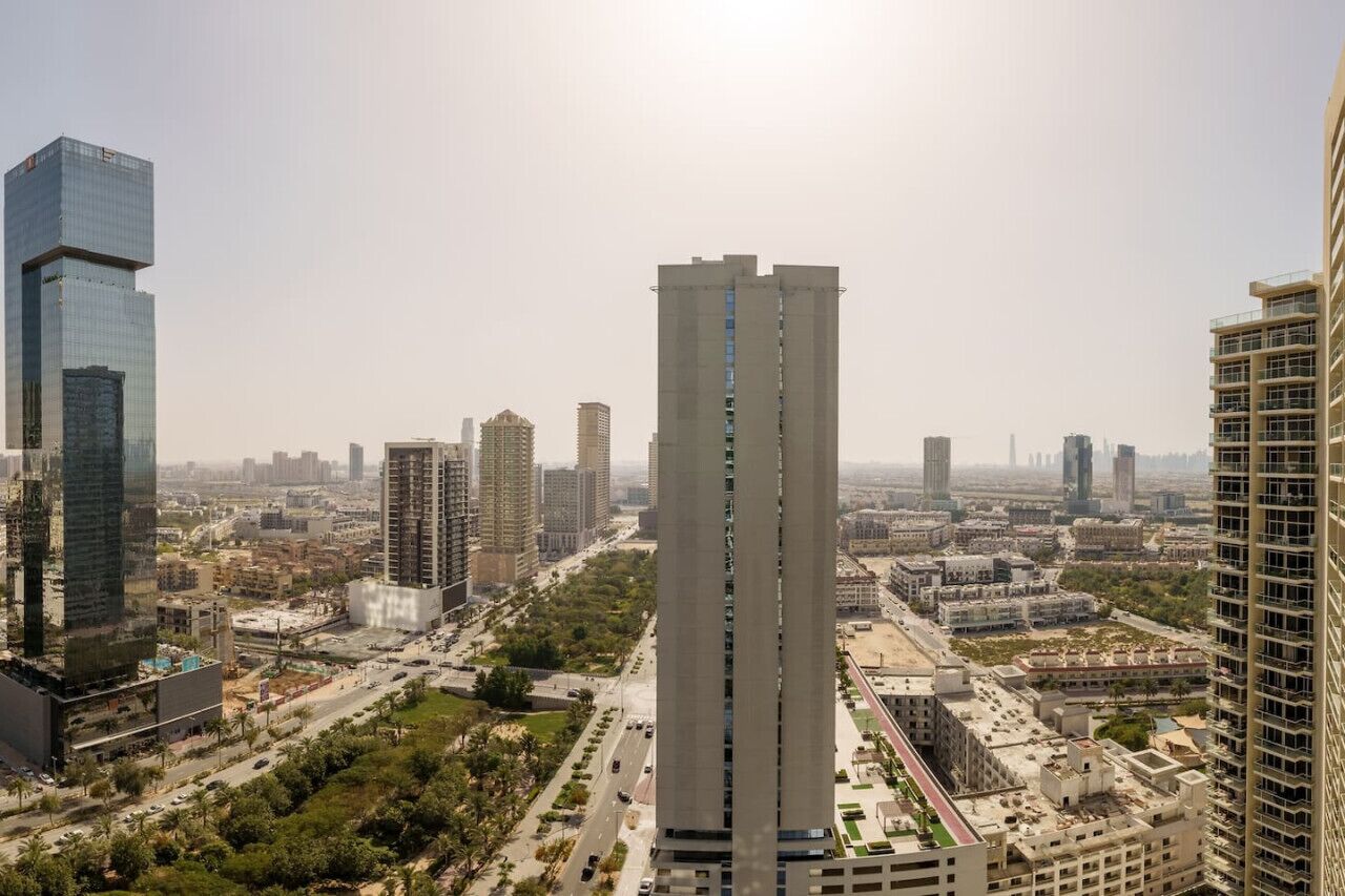 A high-rise building with a modern design, surrounded by other tall buildings and a busy urban environment.