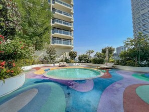 Zona de piscina en la azotea con diseño circular y vegetación circundante.