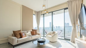 Una sala de estar moderna con un sofá, un sillón y una mesa de centro de vidrio.