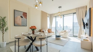 Una sala moderna con comedor, ventanas amplias y vistas a la ciudad.