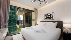 A modern hotel room with a large bed, a desk, and a balcony with a city view. - Luxury Redefined Studio in AHAD Residence (Business Bay)